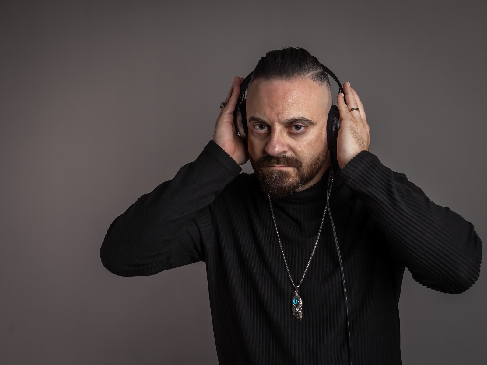 SonicJ wearing headphones in a studio portrait